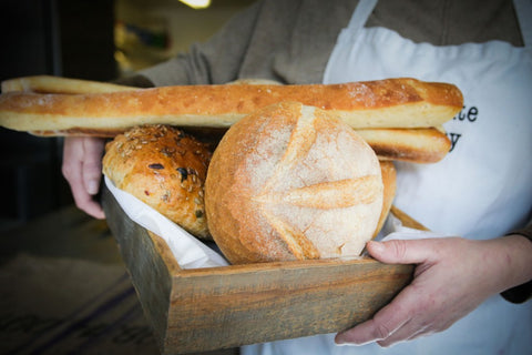 Person holding freshly baked bondgate bread in a wooden basket